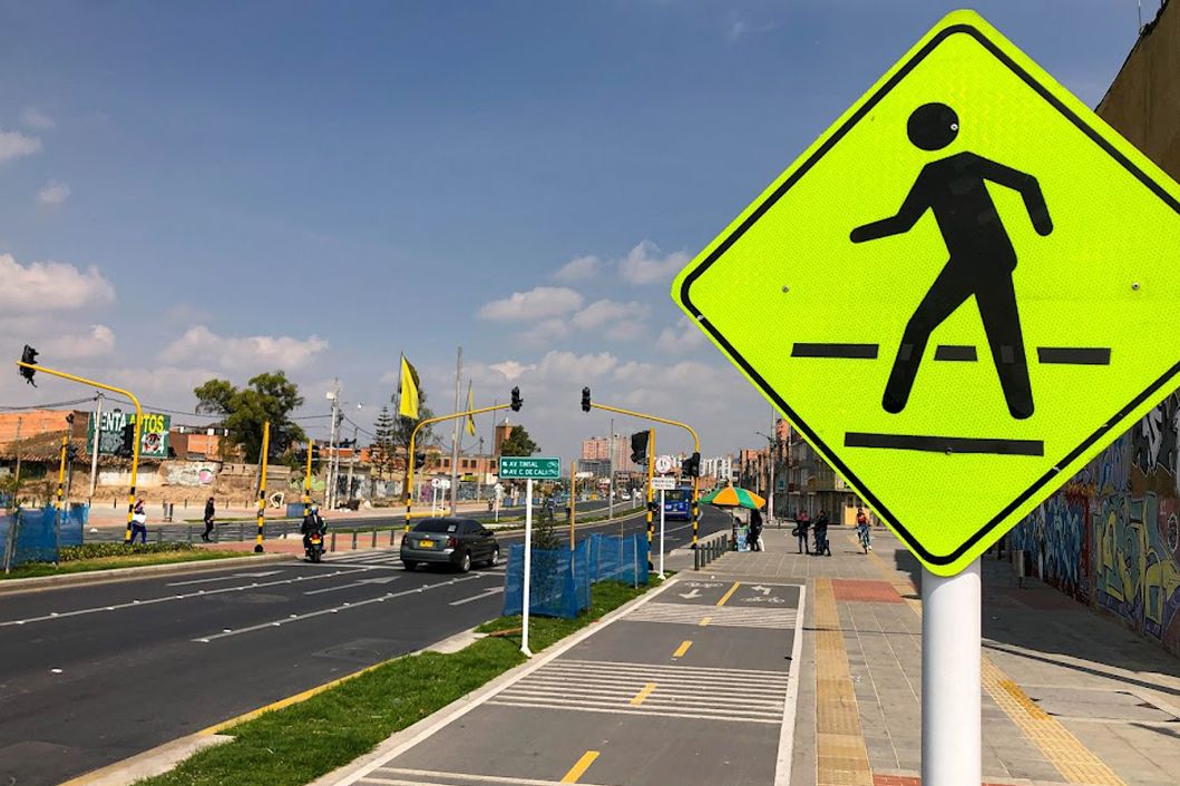 Carril de vehículos  en  Bogotá con una señal de transito en primer plano 