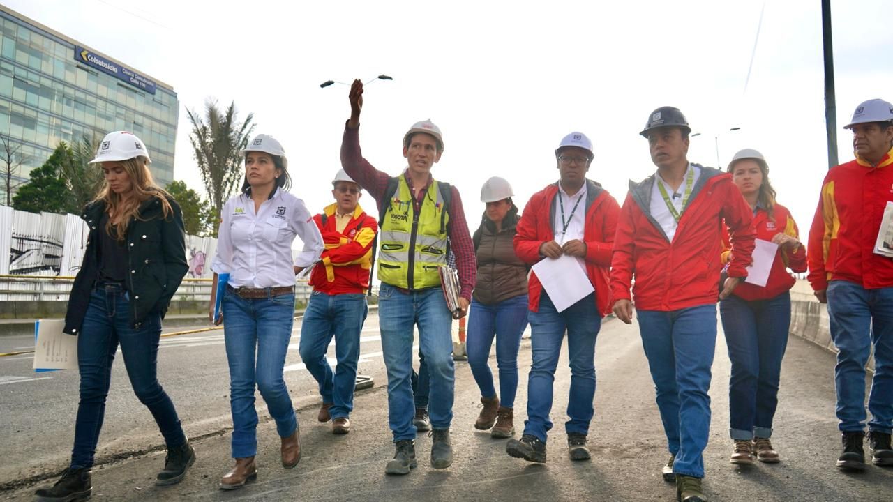 El director del IDU camina jusnto a su equipo de trabajo sobre la av. 68 donde le dan a conocer los avances de las obras
